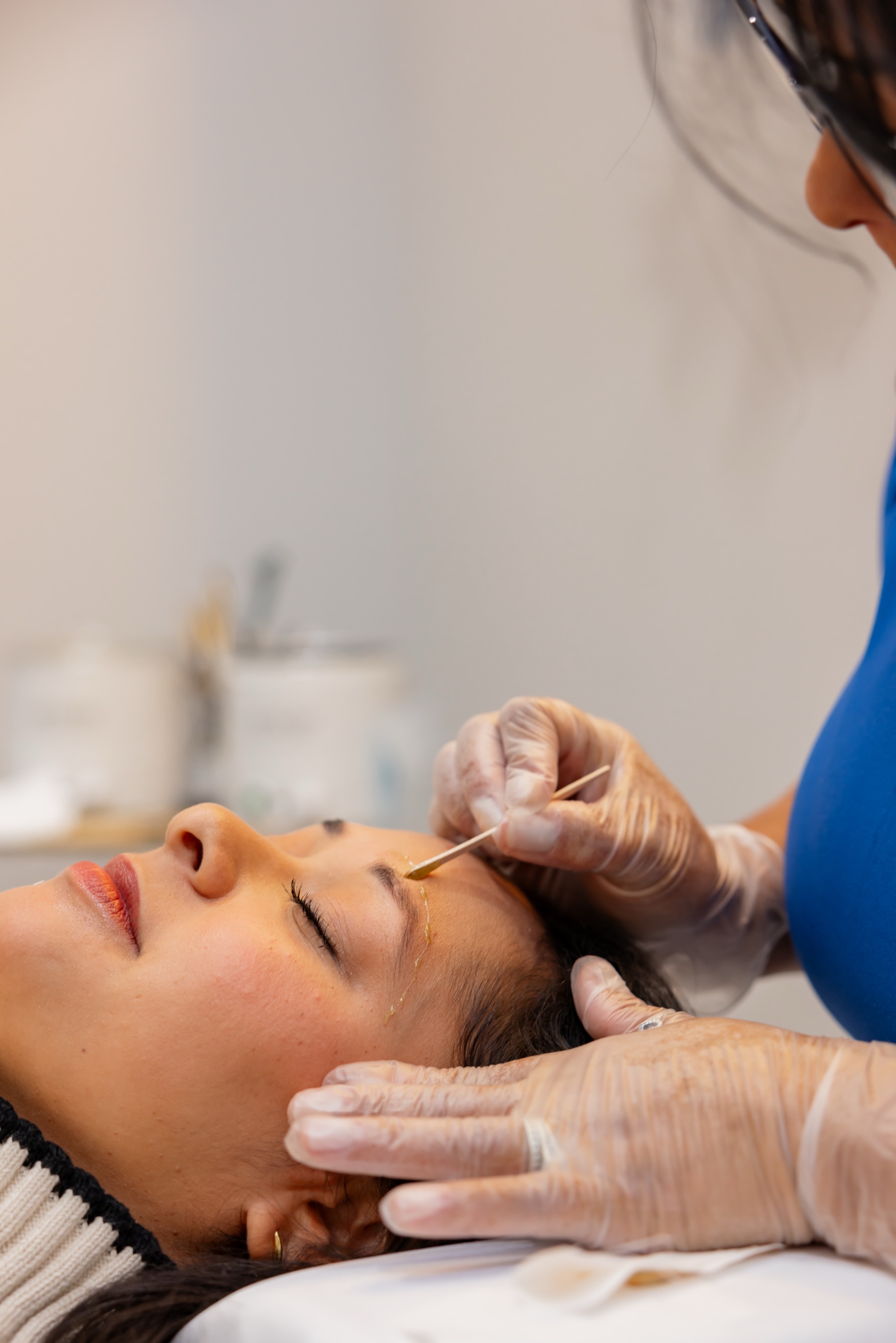 Cida applying hard wax to a client's brow at Luxe Wax Spa, Newtown CT