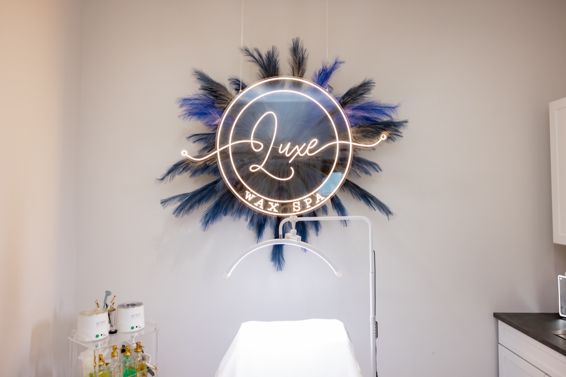 Treatment table and Luxe Wax Spa neon sign in the private suite